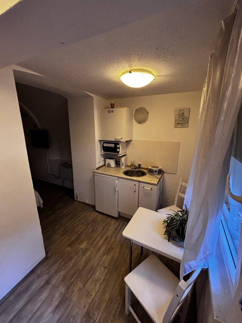 Kleine Küchenzeile mit Esstisch, Fenster und direktem Zugang zum Außenbereich.