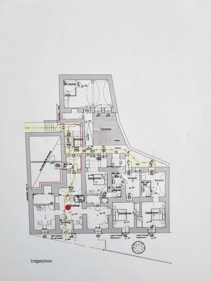 Grundriss des Erdgeschosses mit mehreren Zimmern, einer Terrasse und Treppen.