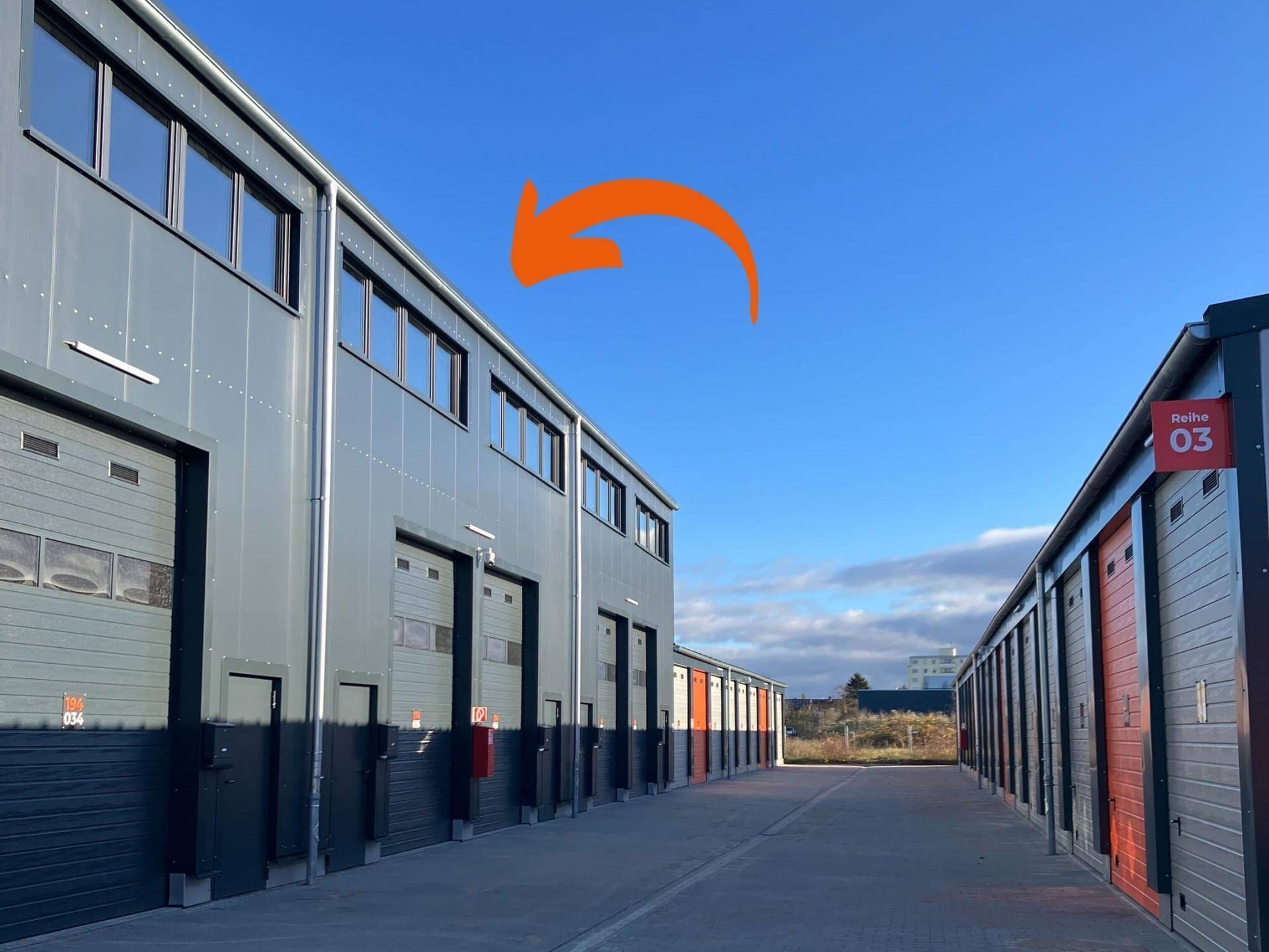 Außenansicht moderner Lagerhallen und Self-Storage-Einheiten unter blauem Himmel.