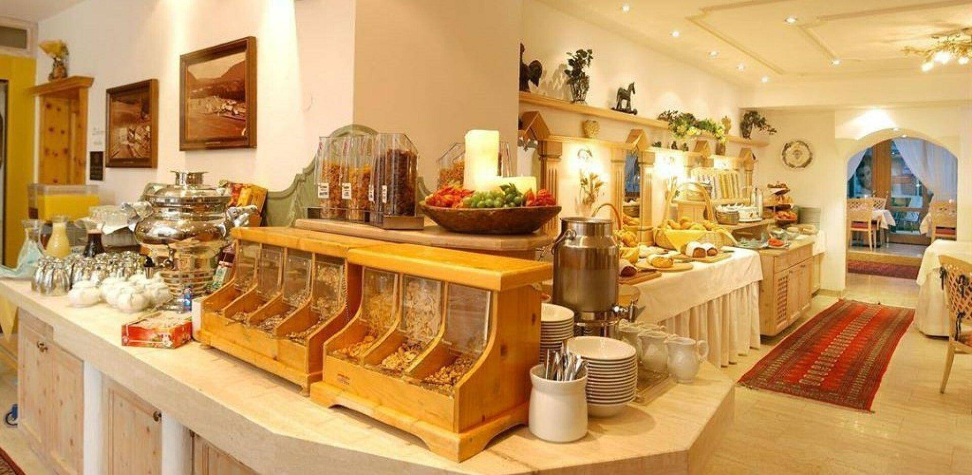 Reichhaltiges Frühstücksbuffet mit verschiedenen Speisen und Getränken in einem hellen, einladenden Bereich des Hotels.