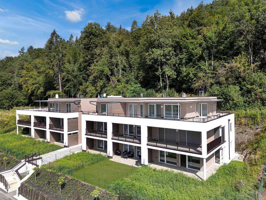 Seitliche Ansicht der modernen Wohnanlage mit mehreren Etagen und großzügigen Balkonen.