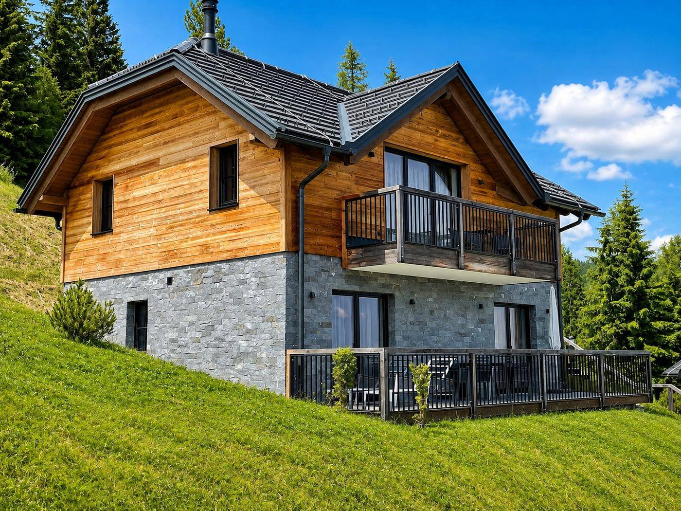 Attraktives Chalet mit Holzverkleidung und Steinsockel, ausgestattet mit Balkon und Terrasse.