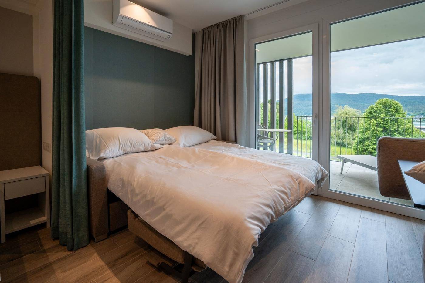Gemütliches Schlafzimmer mit Doppelbett, Klimaanlage und direktem Zugang zum Balkon.