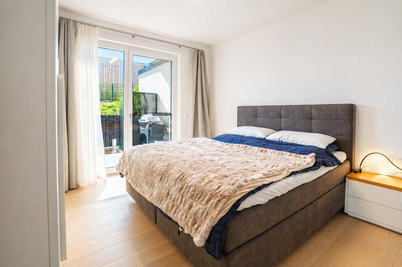 Gemütliches Schlafzimmer mit Doppelbett und direktem Zugang zu einem privaten Balkon.