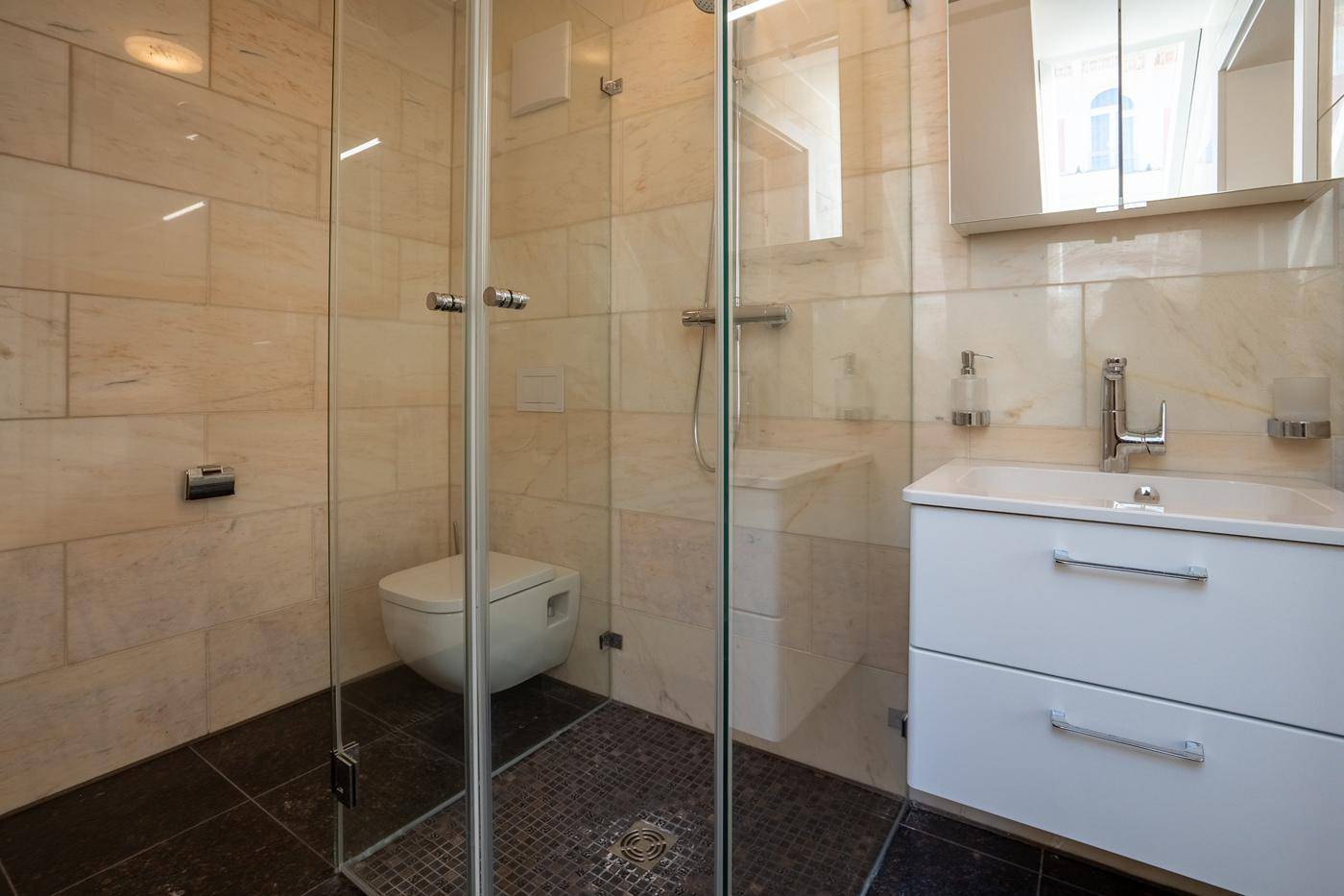 Modernes Badezimmer mit begehbarer Dusche, Wand-WC und eleganten Fliesen in hellen Farbtönen.