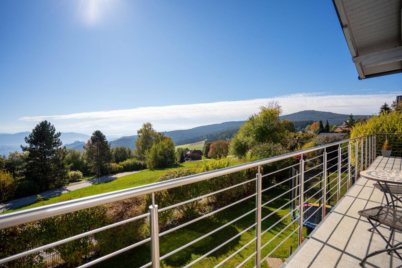 Geräumiger Balkon mit Metallgeländer und atemberaubendem Panoramablick auf die umliegende Berglandschaft.