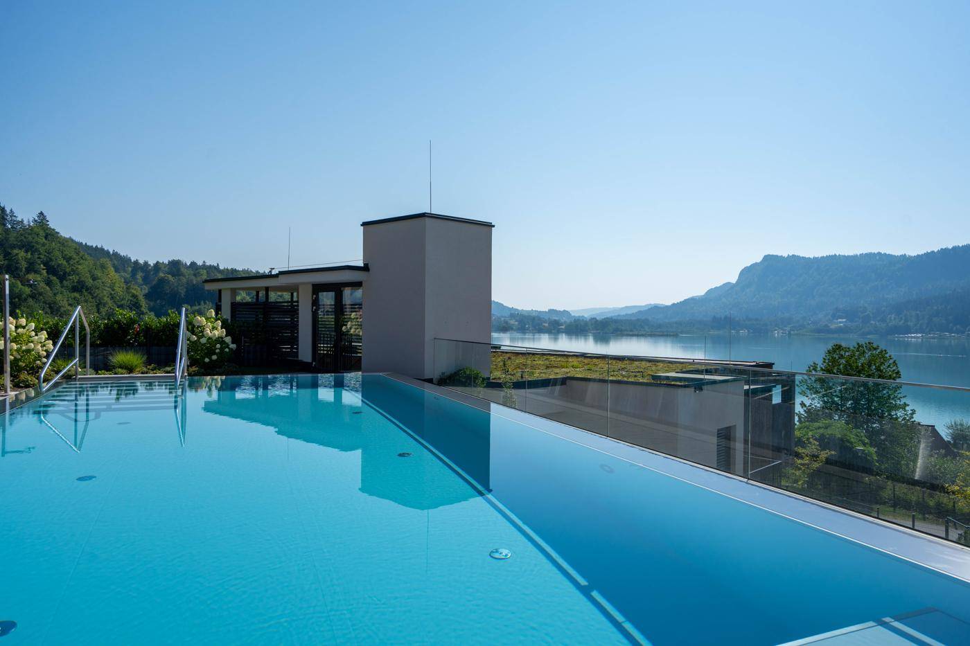 Infinity-Pool mit atemberaubendem Blick auf den See und die umliegende Berglandschaft.