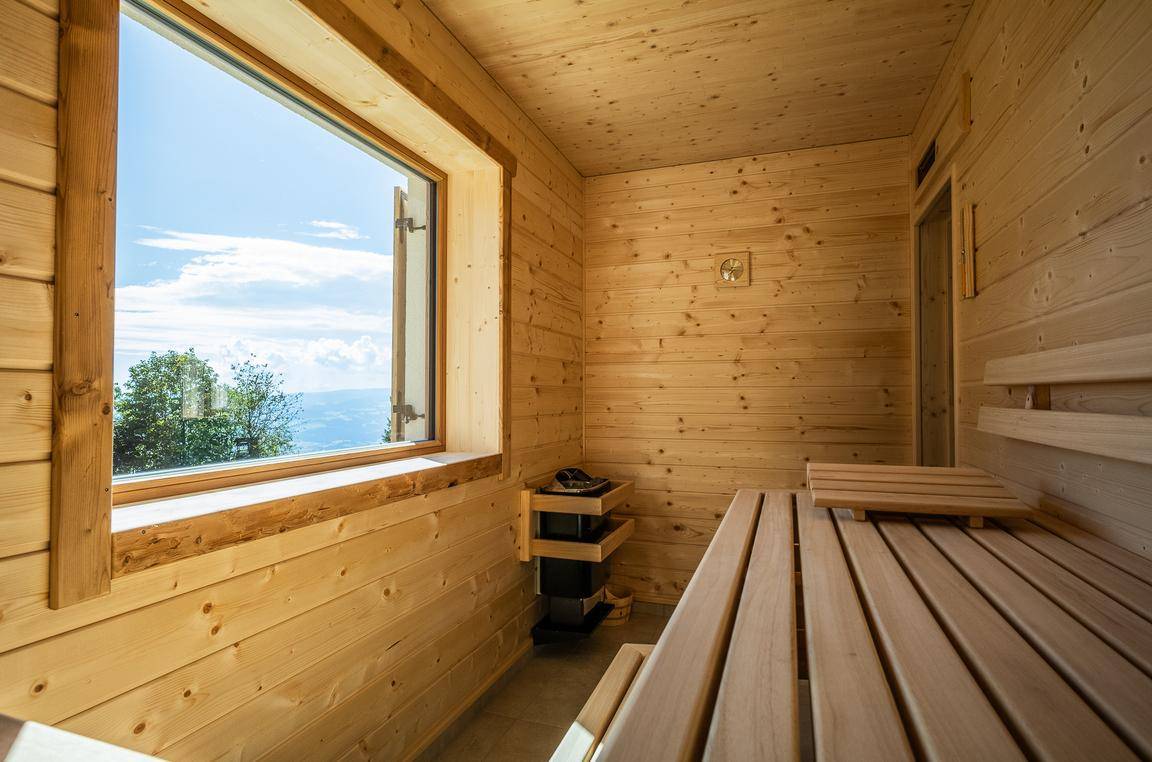 Gemütliche Holzsauna mit Sitzbänken und einem Fenster mit weitem Ausblick.