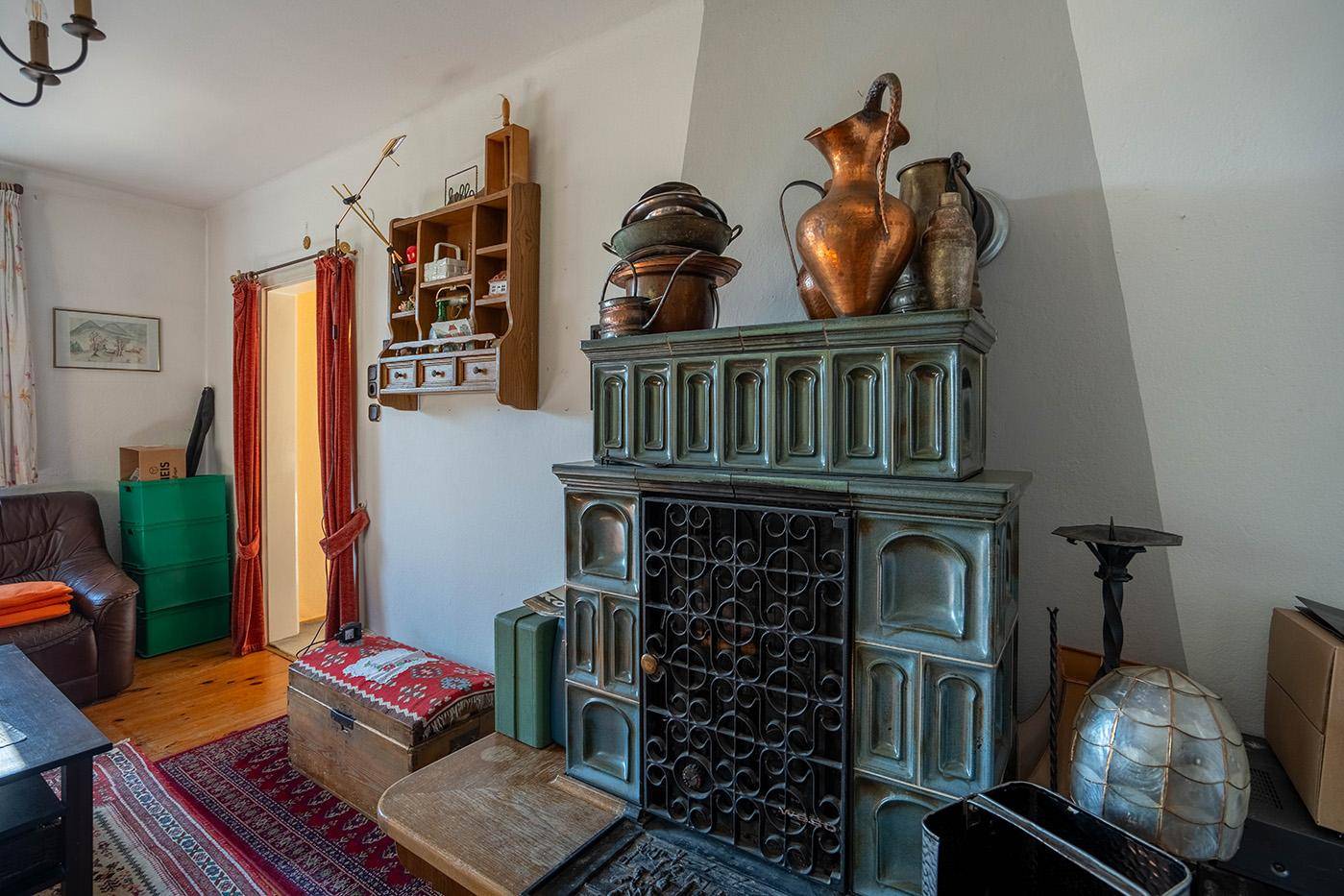 Historischer Kachelofen als zentrales Heizelement und dekorativer Blickfang im Wohnzimmer.