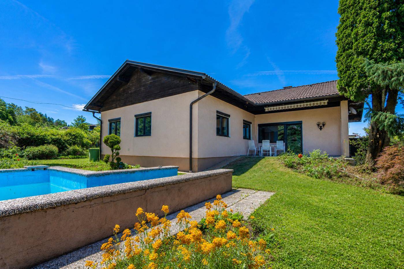 Gepflegtes Einfamilienhaus mit Außenpool, sonnigem Garten und Terrasse im Grünen.