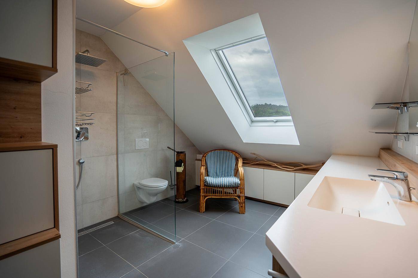Modernes Badezimmer im Dachgeschoss mit begehbarer Dusche und Dachfenster.