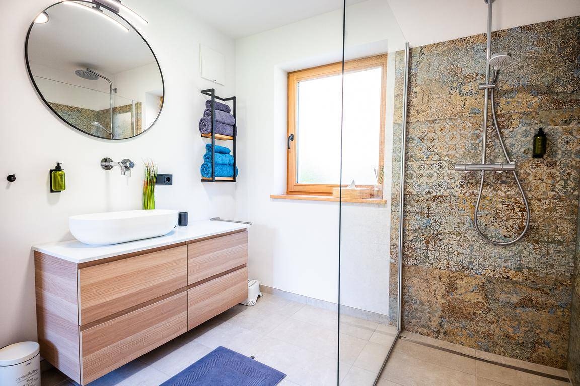 Modernes Badezimmer mit begehbarer Dusche, Einzelwaschbecken und einem Fenster für Tageslicht.