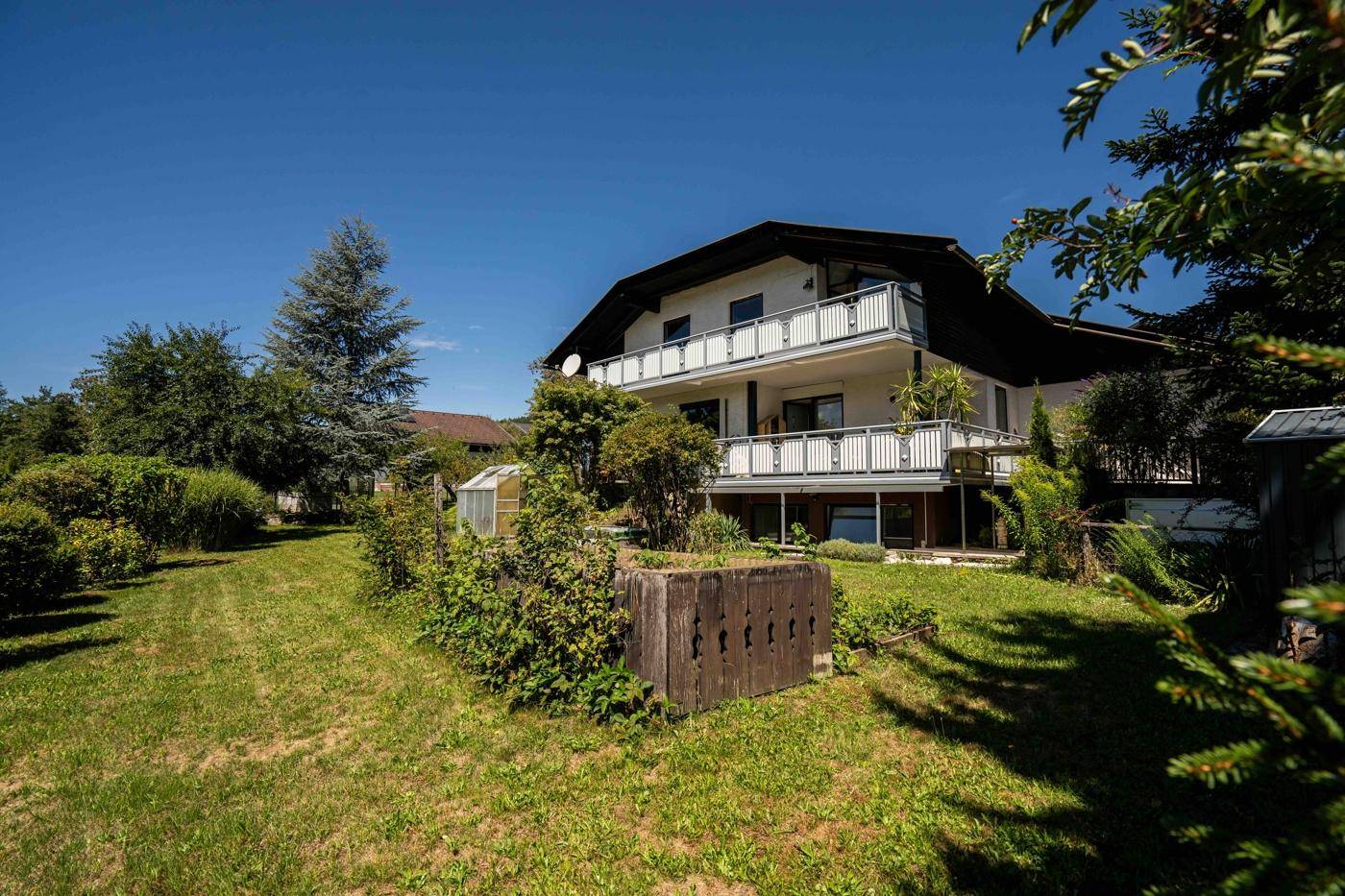 Weitläufiger Garten mit gepflegtem Rasen und Blick auf die Rückseite des Hauses.