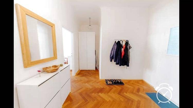 Geräumiger Flur mit Fischgrätparkett, großem Spiegel und praktischer Garderobe.