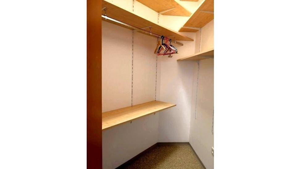 Praktischer begehbarer Kleiderschrank mit Regalen und Kleiderstange.