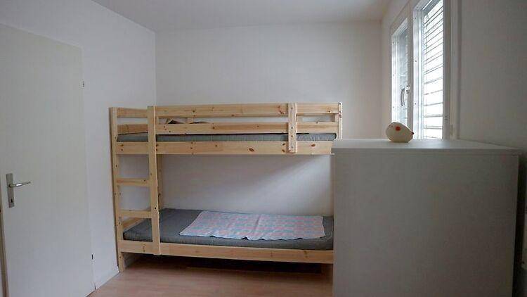 Kinderzimmer mit Etagenbett und Fenster, ideal für Geschwister oder Gäste.