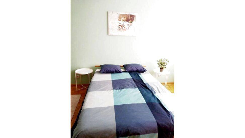 Gemütliches Schlafzimmer mit Doppelbett, Nachttischen und einer beruhigenden Wandfarbe für erholsamen Schlaf.