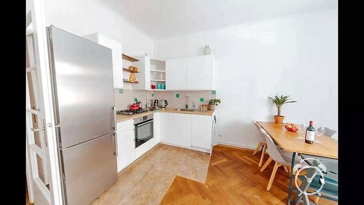 Funktionale Küche mit weißen Schränken, Gasherd und Essbereich, ideal für gemeinsame Mahlzeiten.
