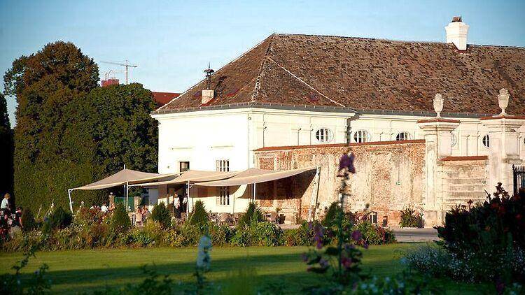 Historisches Gebäude mit großem Garten und schattigem Außenbereich für Gäste.