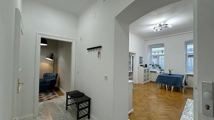 Heller Flur mit Garderobe, Marmorboden und Blick in den offenen Wohnbereich.