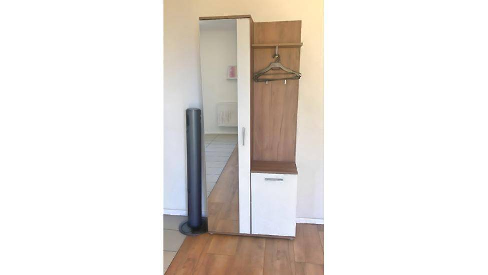 Eingangsbereich mit Garderobenschrank, Spiegel und Laminatboden.