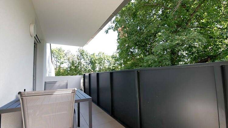 Geräumiger Balkon mit Sitzgelegenheiten und Blick ins Grüne.