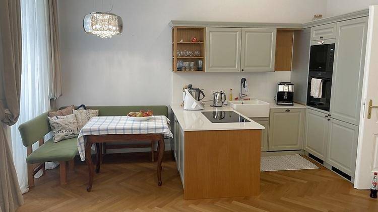 Moderne Küche mit integrierten Geräten, Essbereich und Fischgrätparkett.
