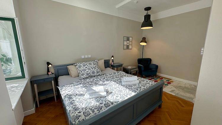 Geräumiges Schlafzimmer mit Doppelbett, Nachttischen und Lesesessel in einer gemütlichen Ecke.