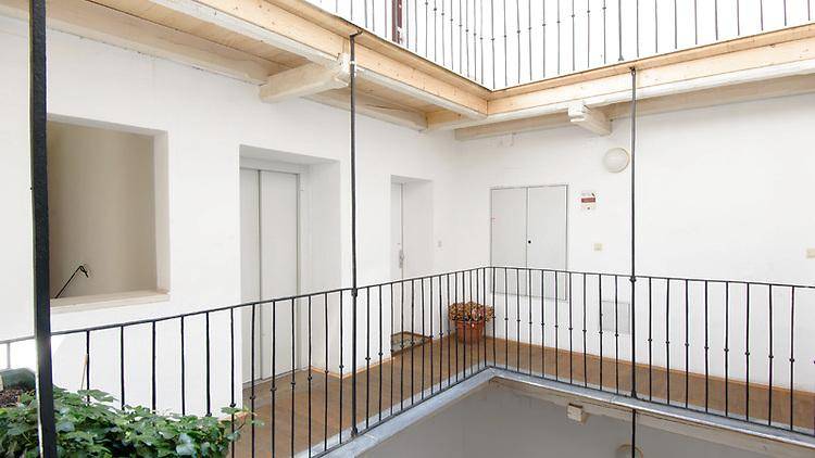 Heller Innenhof eines Gebäudes mit Galerien und Zugang zum Aufzug.