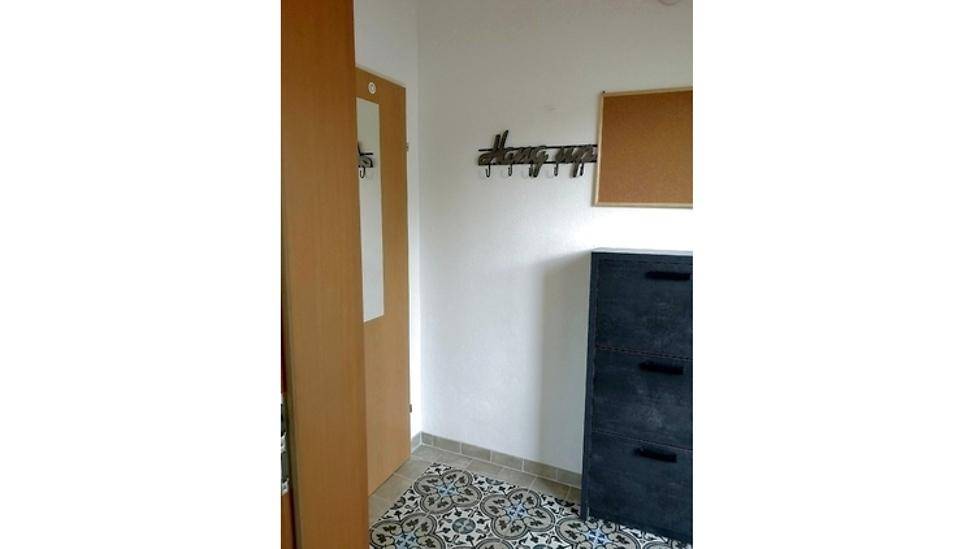Flur mit Schuhschrank, Pinnwand und Garderobe, praktisch eingerichtet.