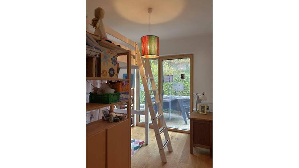 Kinderzimmer mit Hochbett, Leiter und Zugang zu einem Außenbereich.
