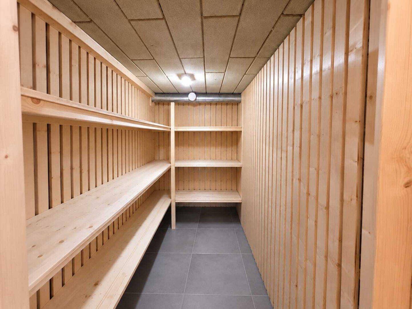 Praktischer Abstellraum mit Holzregalen und Fliesenboden für zusätzlichen Stauraum.