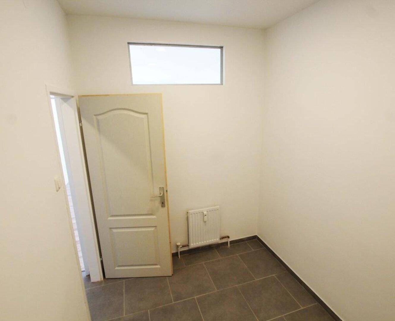 Weiterer Blick in den kleinen Raum mit Fliesenboden und Oberlicht, geeignet für Lagerzwecke.