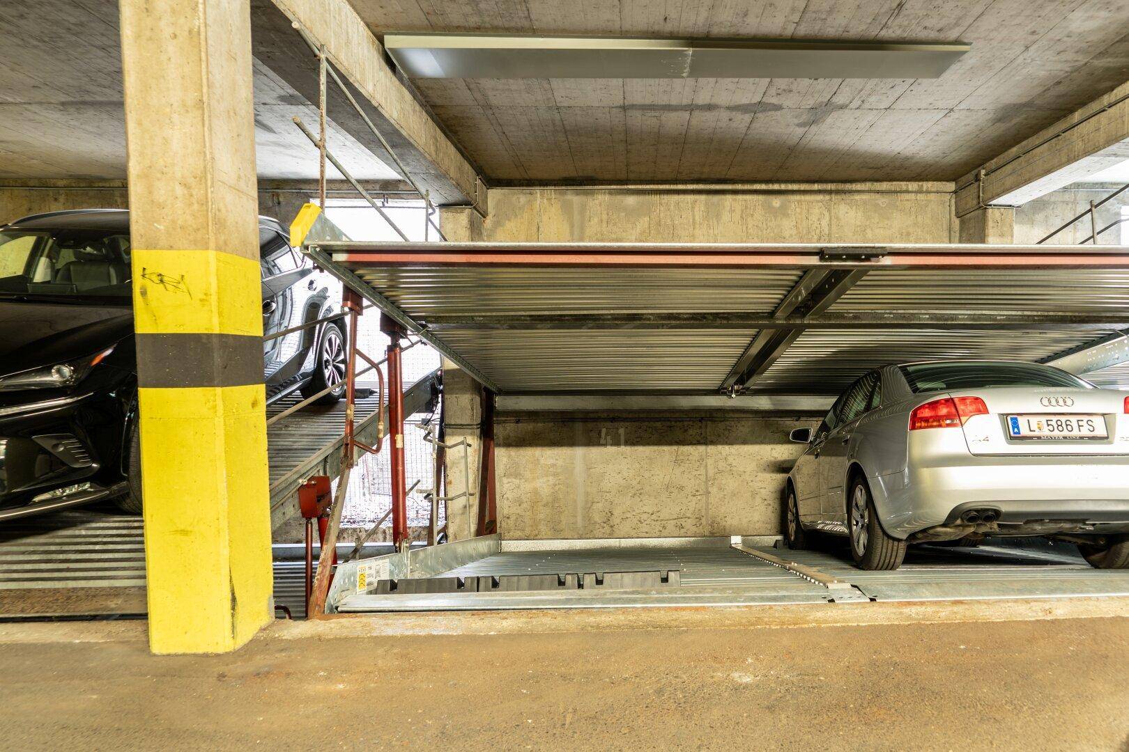 Detailansicht des Doppelparker-Systems in einer Tiefgarage mit zwei geparkten Fahrzeugen.
