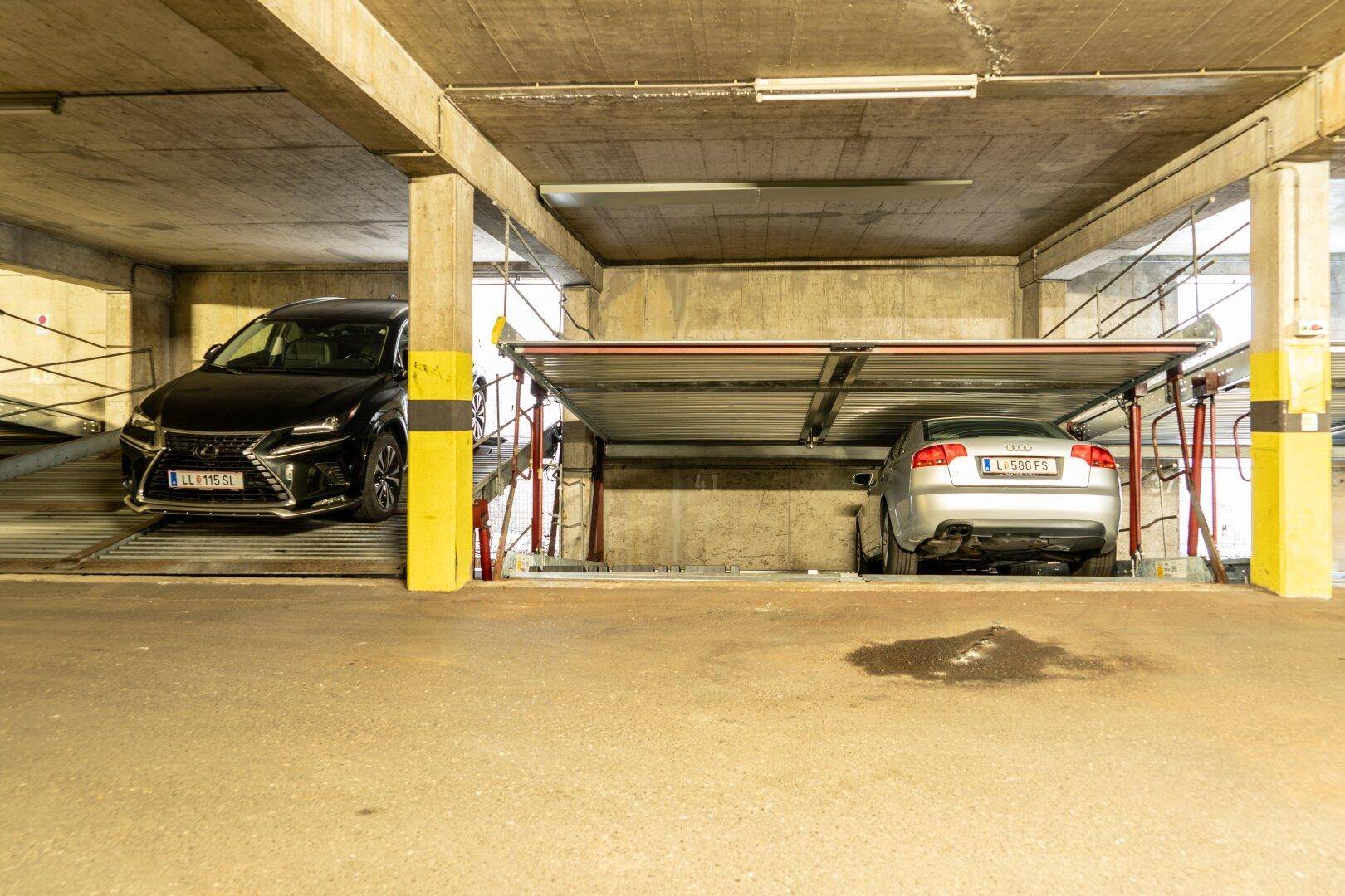 Tiefgarage mit modernen Doppelparkern, die zwei Fahrzeuge aufnehmen können.