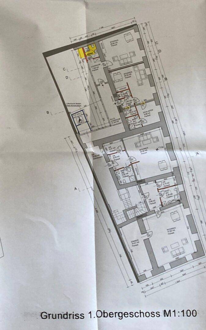 Grundriss des ersten Obergeschosses mit mehreren Wohneinheiten und einem Aufzug.