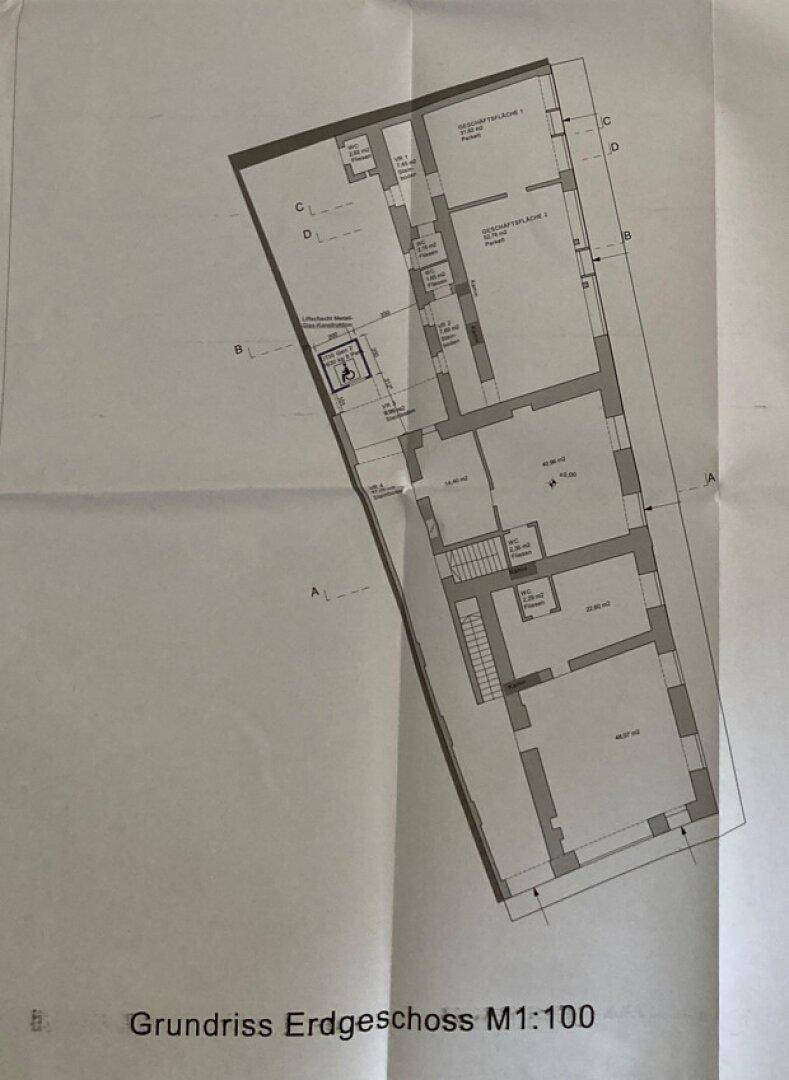 Grundriss des Erdgeschosses mit verschiedenen Räumen und einem Aufzug.