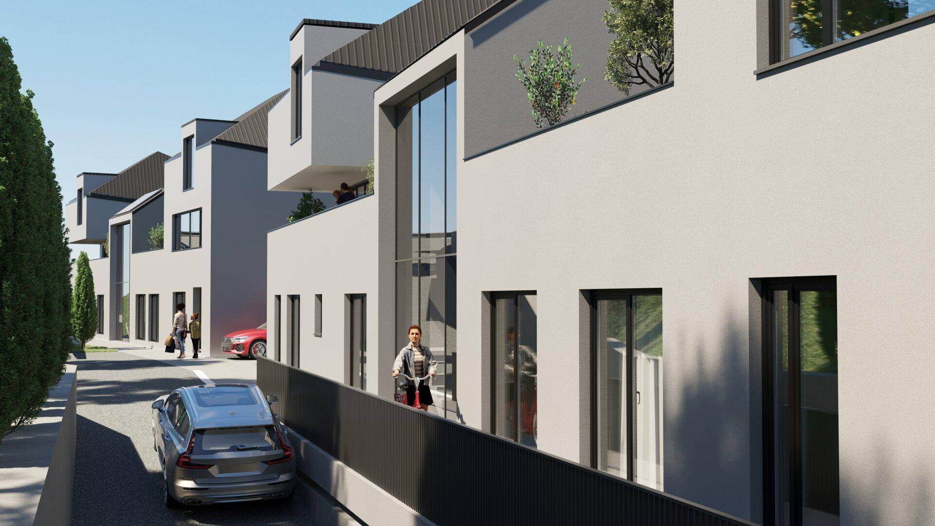 Moderne Reihenhäuser mit klaren Linien und großen Glasfronten an einer Wohnstraße.