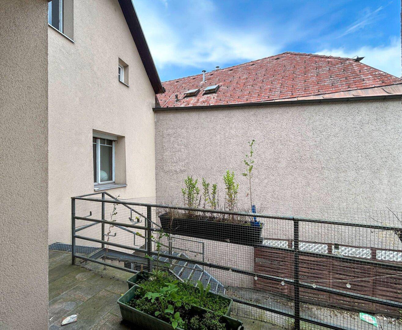 Kleiner Balkon mit Metallgeländer und Pflanzen, bietet einen Blick auf die Umgebung.