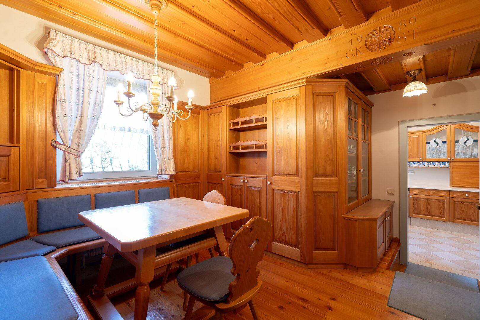 Gemütliche Essecke mit Holztäfelung, Einbaubank und traditionellem Esstisch, ideal für Familienmahlzeiten.