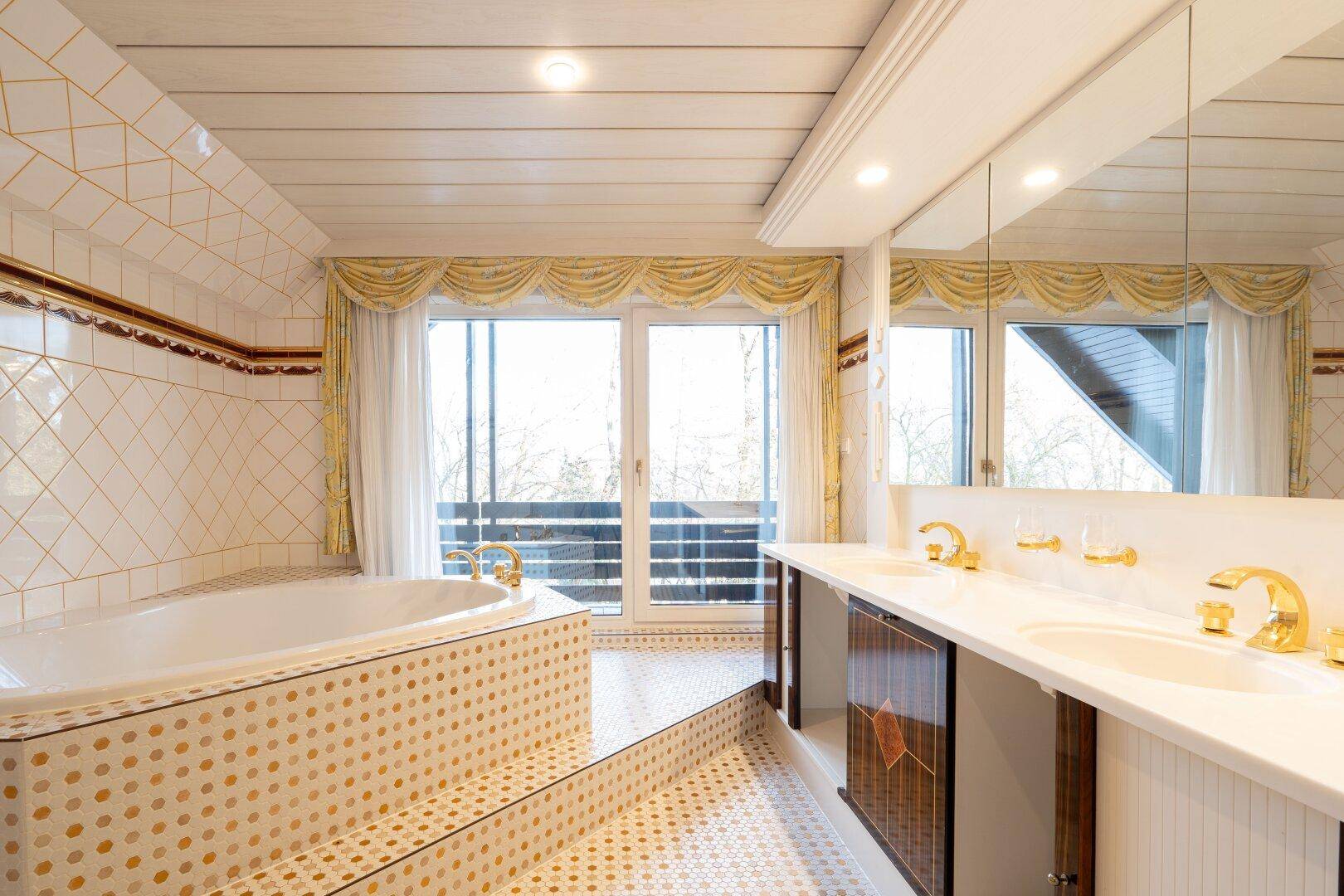 Helles Badezimmer mit Doppelwaschbecken, Badewanne und Balkonblick, das viel Komfort bietet.
