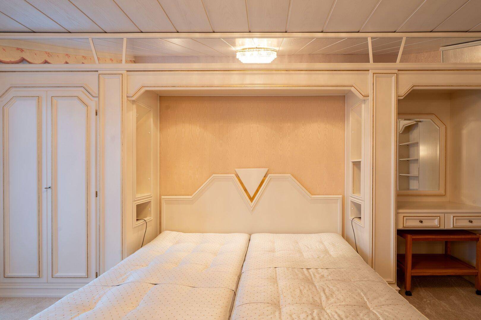 Schlafzimmer mit integriertem Bett, Einbauschränken und heller Einrichtung, die eine ruhige Atmosphäre schafft.