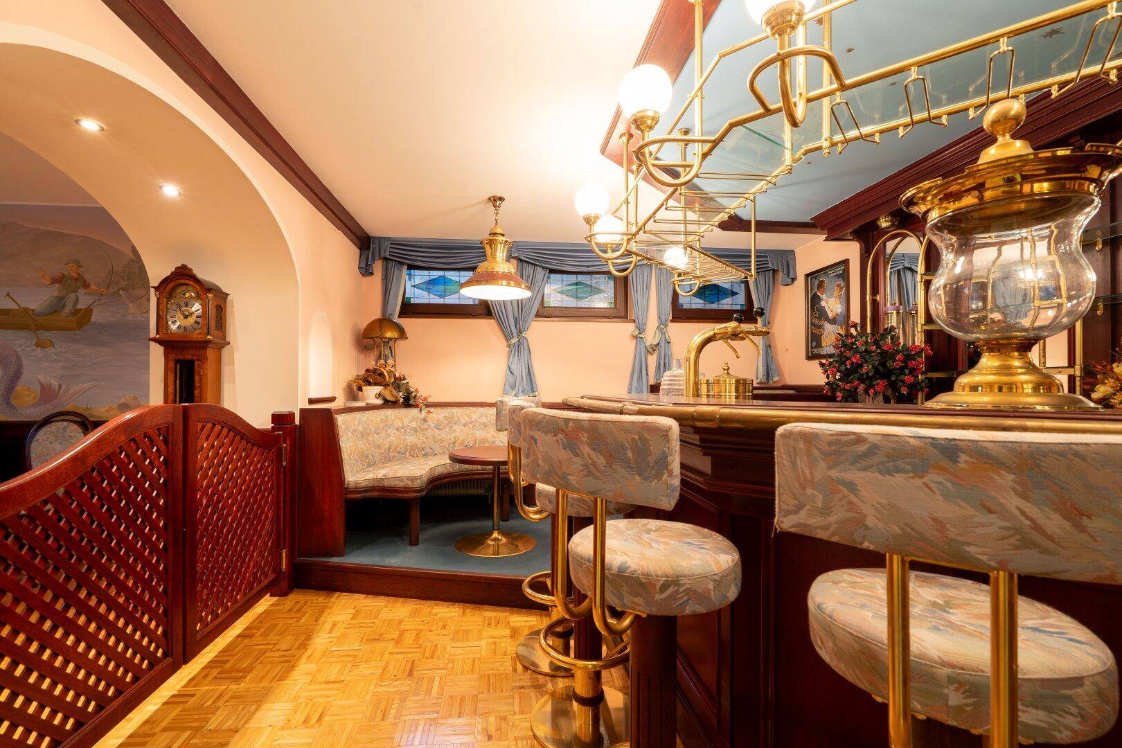 Gemütliche Bar im Keller mit Holzboden, Barhockern und traditioneller Einrichtung, ideal für Unterhaltung.