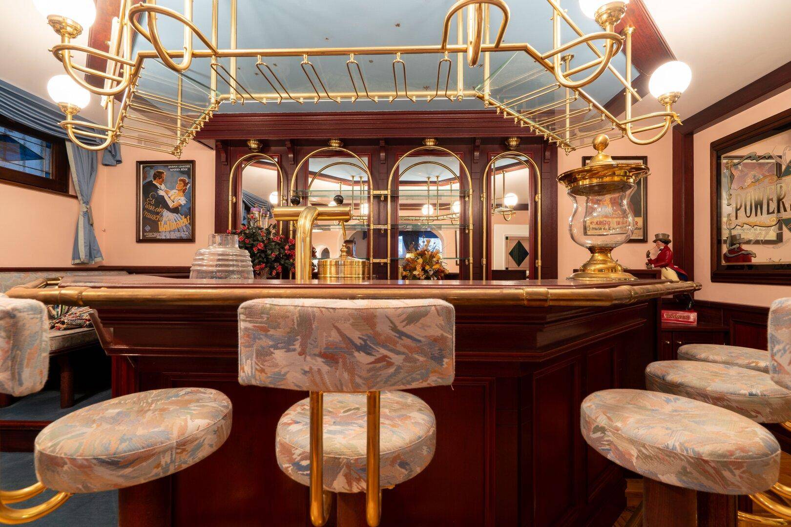 Detailreiche Bar im Keller mit goldenen Akzenten und gemütlicher Atmosphäre, die zum Verweilen einlädt.