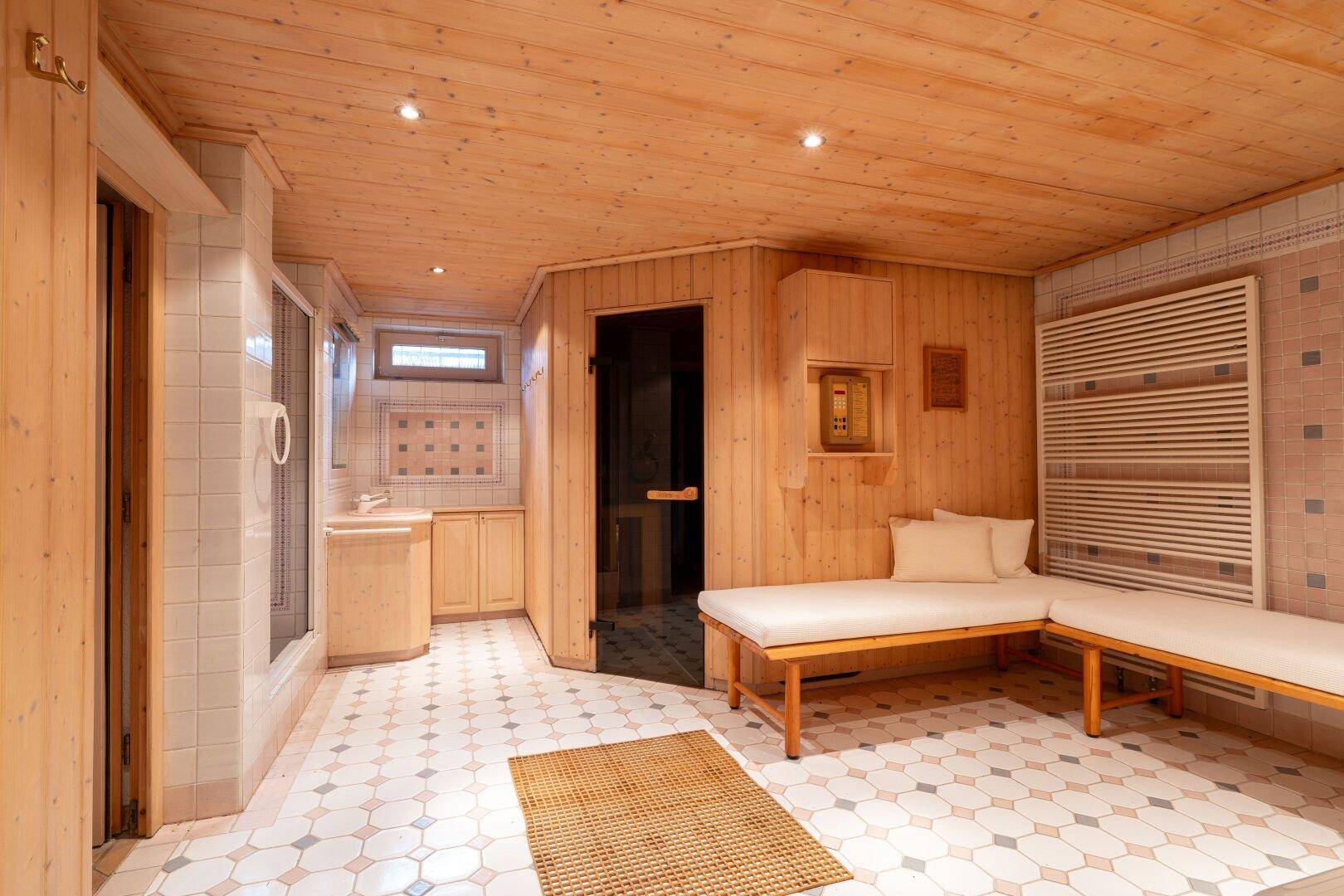 Wellnessbereich mit Sauna, Liegen und Holztäfelung, der zur Entspannung einlädt.