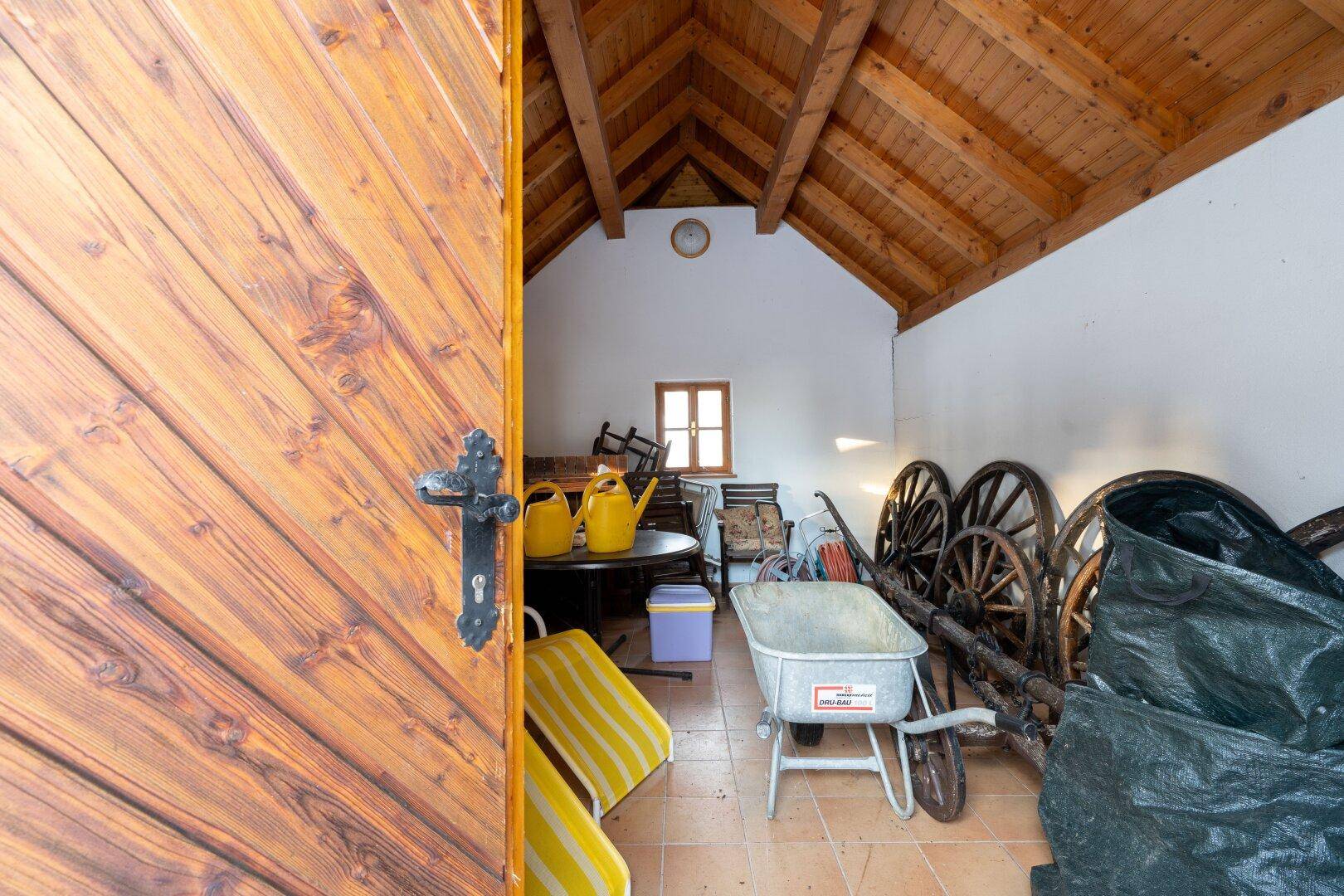 Praktischer Abstellraum im Dachgeschoss mit Holzdach und verschiedenen Geräten, der viel Platz bietet.