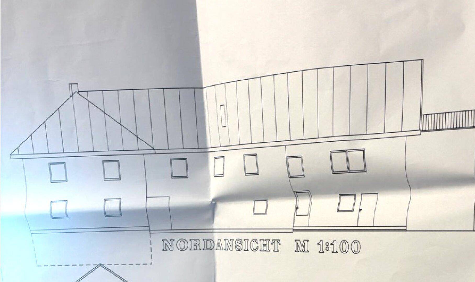 Nordansicht des Gebäudes im Maßstab 1:100, zeigt die Fassade mit mehreren Fenstern.