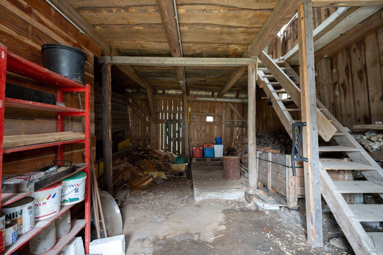 Geräumiger Holzschuppen mit offener Konstruktion und Holzstapeln, ideal als Lagerraum.