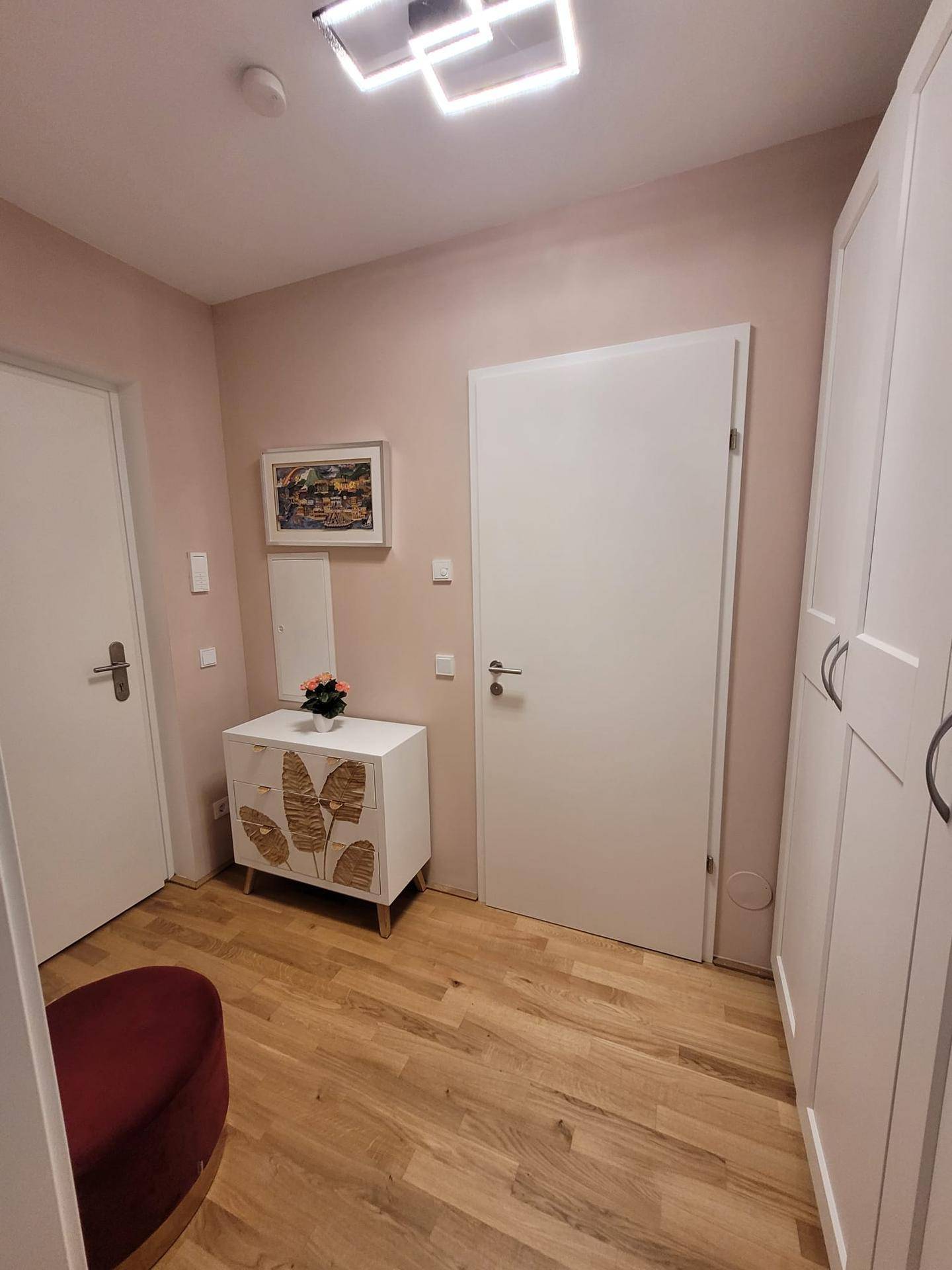 Eingangsbereich mit weißer Kommode, Spiegel und einem praktischen Einbauschrank.