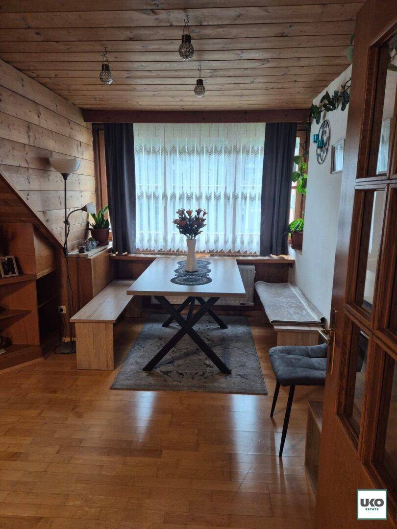 Rustikaler Essbereich mit Holztisch, eingebauten Sitzbänken und Holzdeckenverkleidung.